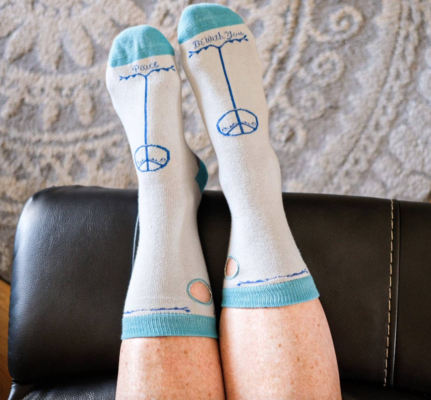 White and pale blue socks with 'peace be with you' written at the toe